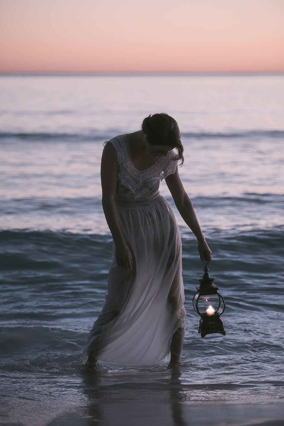 spooky girl on beach with a lantern