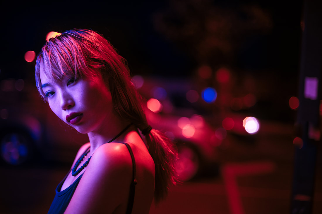 portrait of a girl at night with purple and red lights